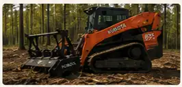 A large orange excavator with a black bucket is parked in a forest.